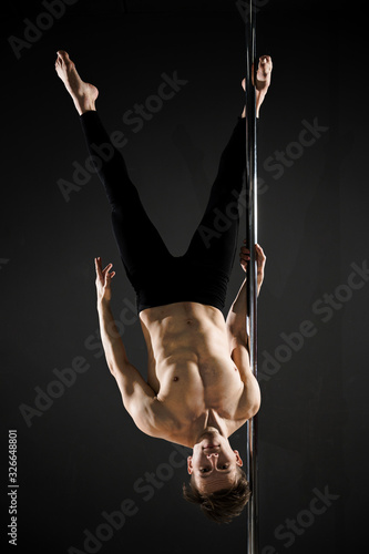 Portrait of young male model pole dancing