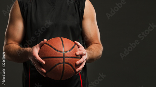 Front view of basketball held by male player with copy space