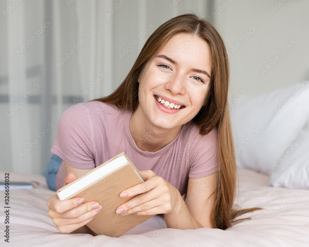 Pretty woman smiling while holding a book Pretty woman smiling while holding a book