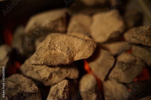 Hot glowing red burning stones inside the sauna oven, stov