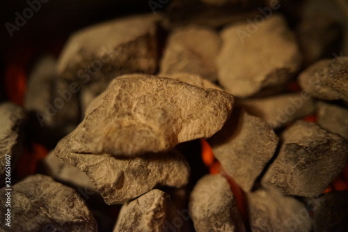 Hot glowing red burning stones inside the sauna oven, stov