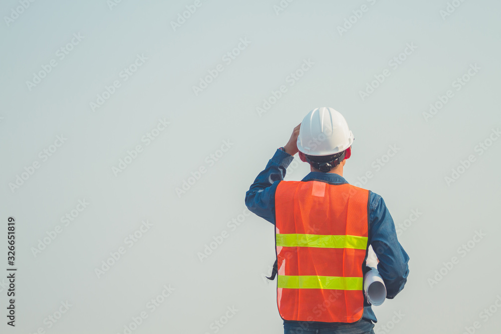 Obraz premium Engineer hold blue prints looking forward with hope and keep going at construction site.