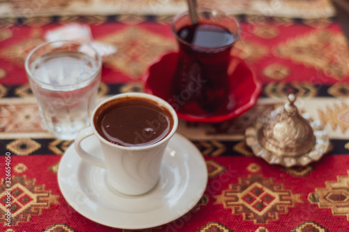 Authentic white cups with black coffee on the table in a Turkish cafe. Lunch coffee expresso. © Uladzimir