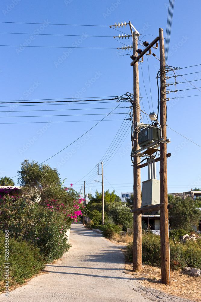 Old wooden electric pole in Greece. Power lines in Arki countryside -  Dodecanese Islands, Greece