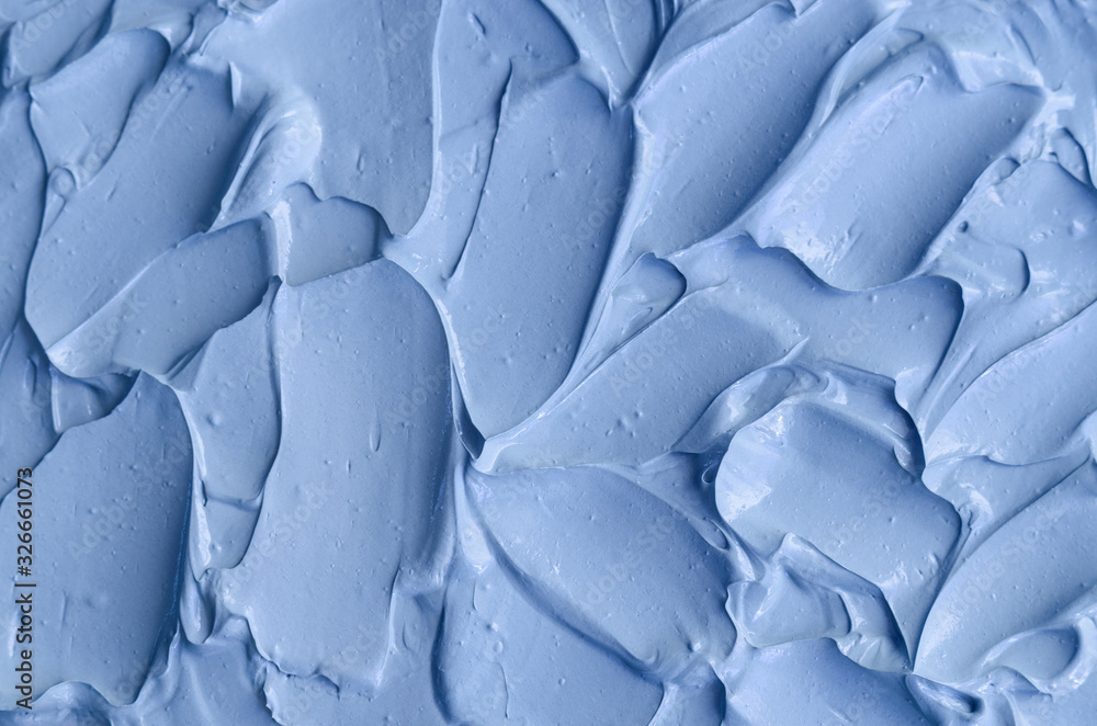 Obraz premium Light blue bentonite facial clay (mask, face cream, body wrap) texture close up, selective focus. Abstract background with brush strokes.