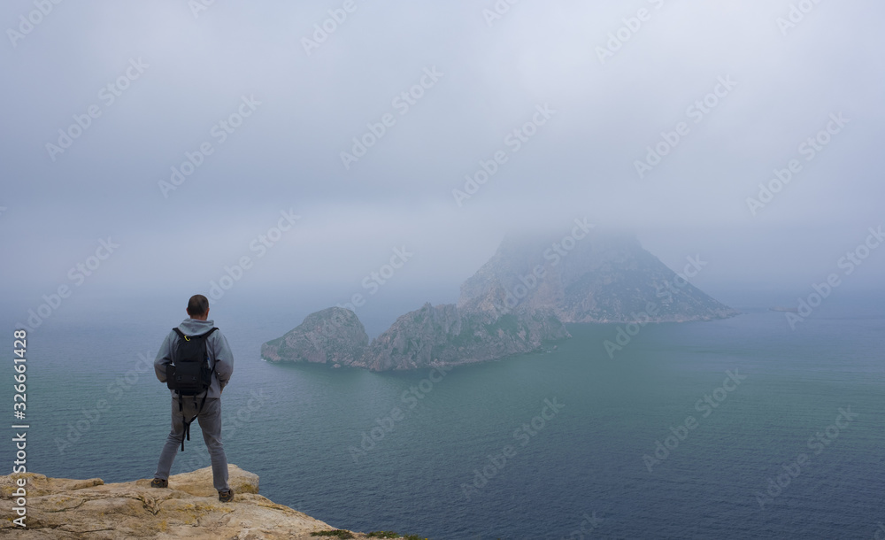 Hiker on the beach of Hort with the island of Es Vedra in the background, Ibiza, Balearic Islands