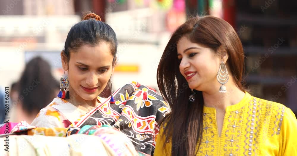 Two women shopping for dress at street market Two women shopping for dress at street market