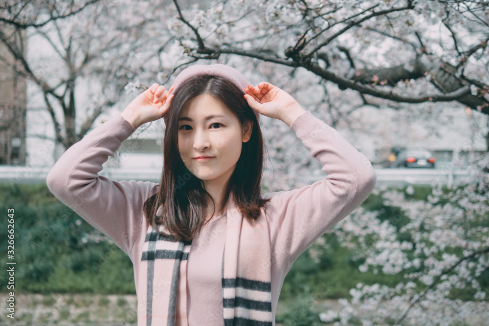 Under the cherry tree, the girl smiles gently Under the cherry tree, the girl smiles gently