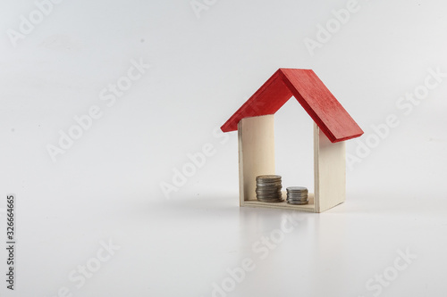 Housing/property concept with small red house isolated on white.