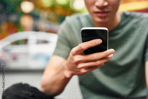 Close up of man using mobile phone in the city