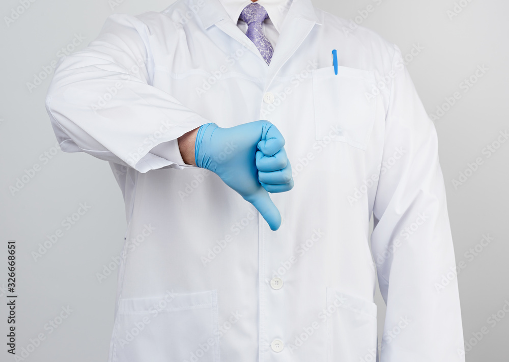 doctor in a white coat with buttons shows a gesture of dislike with his hand doctor in a white coat with buttons shows a gesture of dislike with his hand