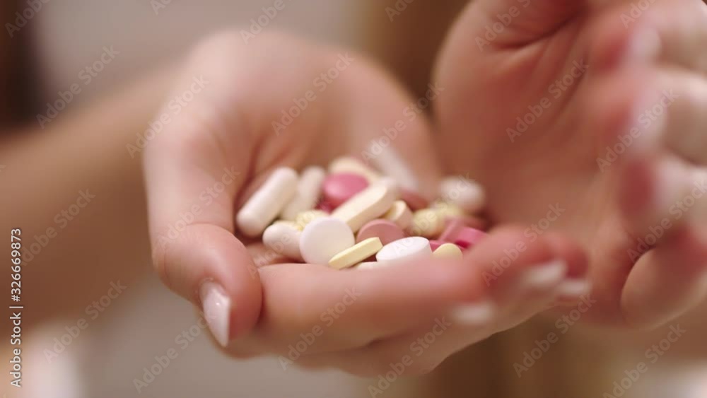 Essential aspirin medicine tablets in closed hands, closeup Essential aspirin medicine tablets in closed hands, closeup