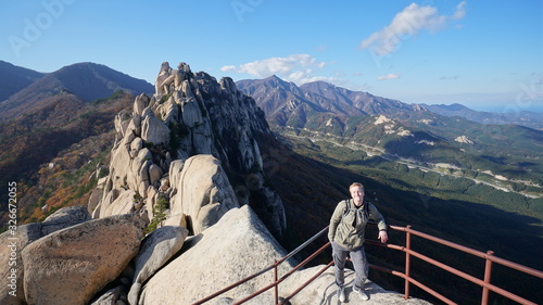 Young man travels on the top of Ulsanbawi mountain in a Seoraksan National Park in South Korea, Asia.	
 photo