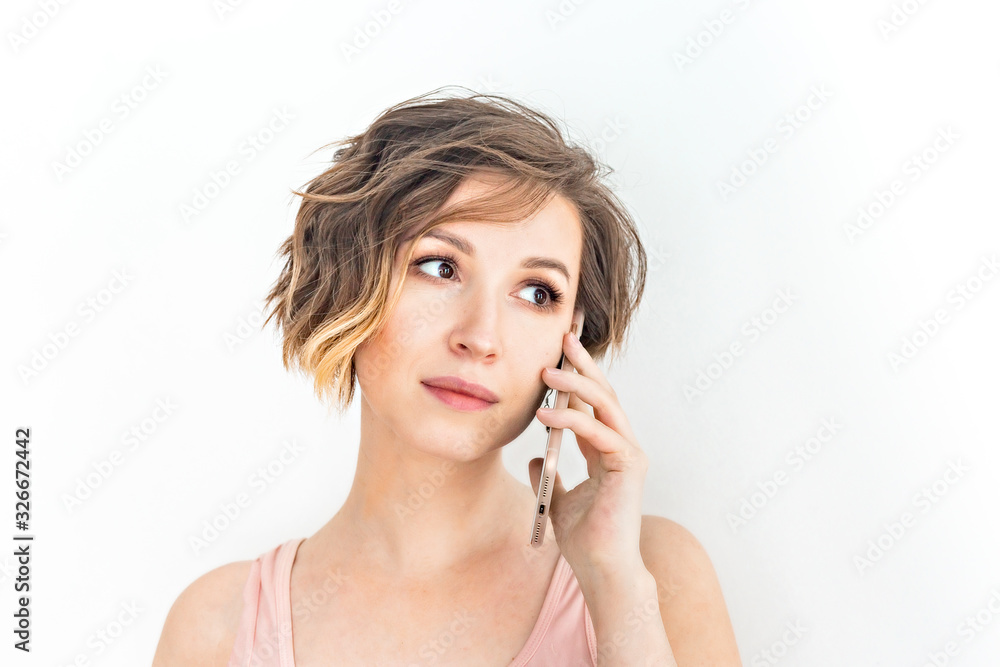 Close up Young Woman Talking to Someone on her Mobile Phone While Looking Into the Distance with Happy Facial Expression on white background Close up Young Woman Talking to Someone on her Mobile Phone While Looking Into the Distance with Happy Facial Expression on white background