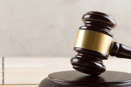 brown gavel with a brass band on a grey background