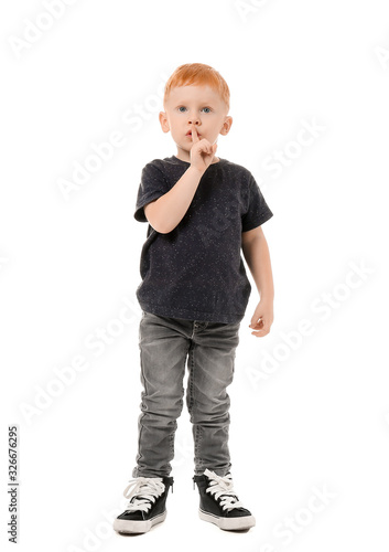 Cute little boy showing silence gesture on white background
