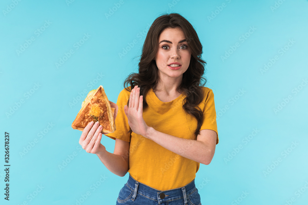 Beautiful woman holding sandwich showing stop gesture. Beautiful woman holding sandwich showing stop gesture.
