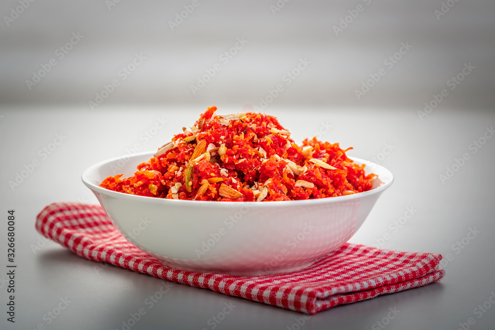 Gajar ka halwa is a sweet dessert pudding from India made from carrot, served in a bowl. Garnished with cashew, almond and pistachio nuts. Gajar ka halwa is a sweet dessert pudding from India made from carrot, served in a bowl. Garnished with cashew, almond and pistachio nuts.