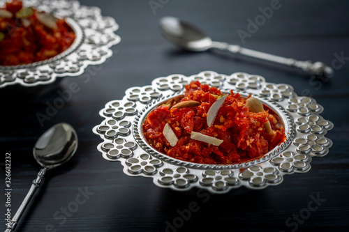  Gajar ka halwa is a sweet dessert pudding from India made from carrot, served in a bowl. Garnished with cashew, almond and pistachio nuts. photo