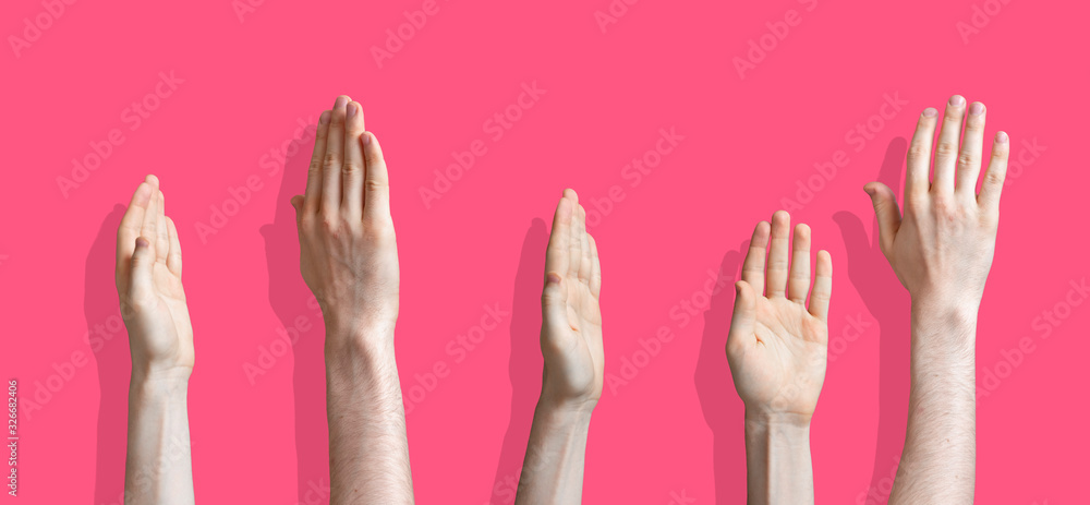 Fototapeta premium five raised human hands isolated on the colourful background as a concept of vote and agree