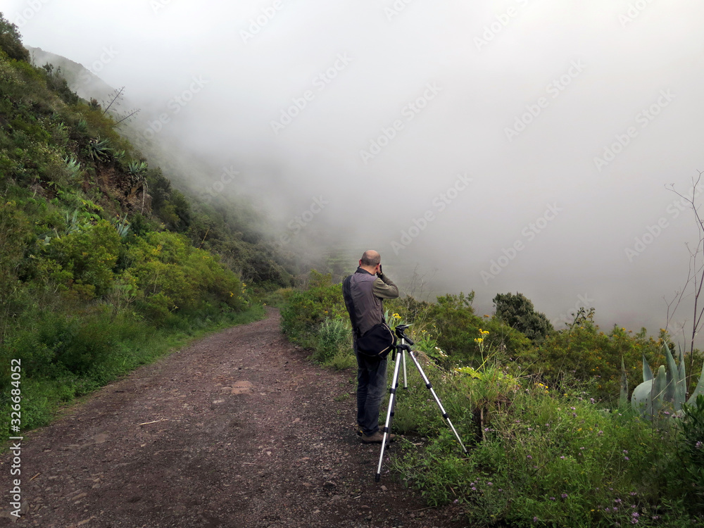 man taking a picture in the middle of the fog