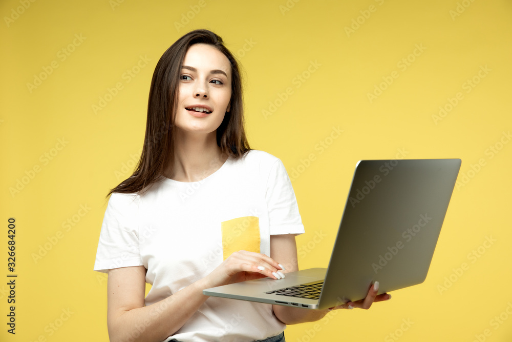 woman with laptop on yellow background, copy space. woman with laptop on yellow background, copy space.