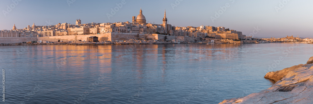 Panorama of Valletta with Our Lady of Mount Carmel church and St. Paul's Anglican Pro-Cathedral at sunrise as seen from Sliema, Valletta, Malta
