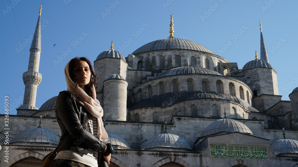 Obraz premium A woman and the Sultanahmet Blue mosque in Istanbul in Turkey.