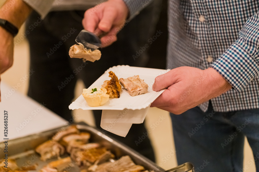 Fashionable man serving himself with food on banquet or celebration event.