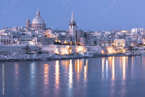 Mystical Valletta with Our Lady of Mount Carmel church and St. Paul's Anglican Pro-Cathedral at sunset as seen from Sliema, Valletta, Malta © Kavalenkava