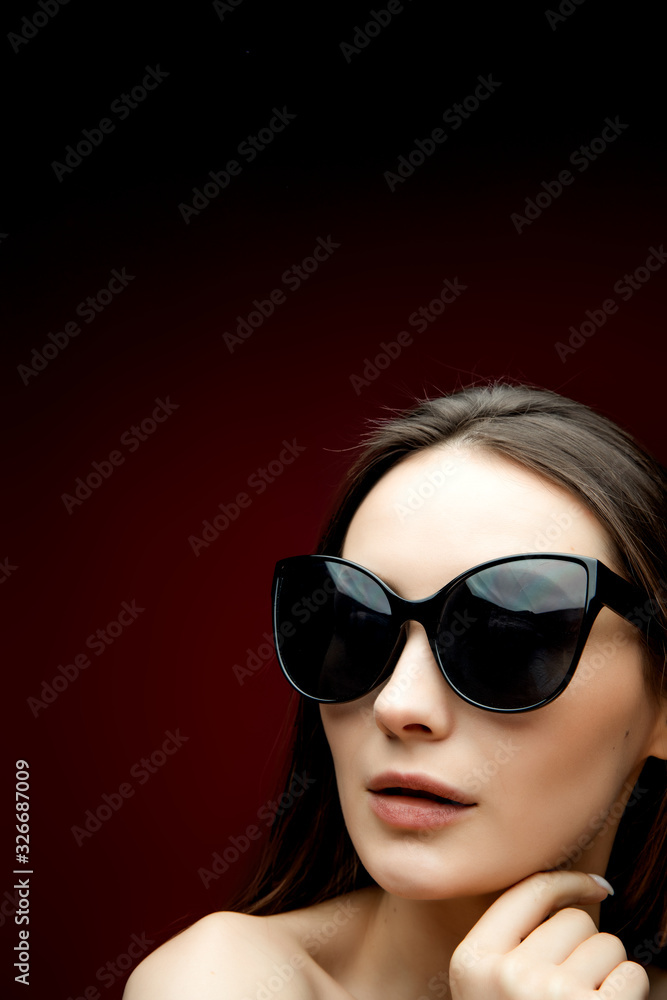 Portrait of beautiful woman in heart-shaped sunglasses. Pretty girl in hoody posing on bright background. Free space for text. Portrait of beautiful woman in heart-shaped sunglasses. Pretty girl in hoody posing on bright background. Free space for text.