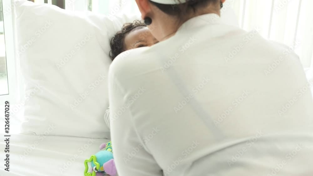 African infant baby is lying on the bed.His mother take care him. African infant baby is lying on the bed.His mother take care him.