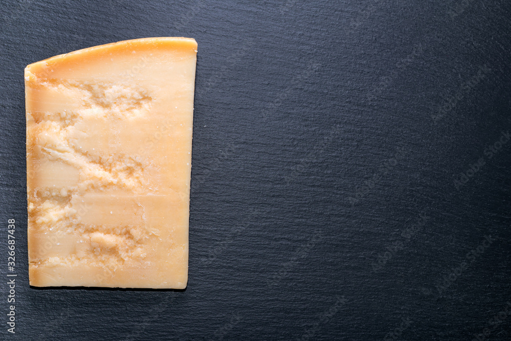 top view of tasty fresh portion cheese parmigiano on black slate background, copy space