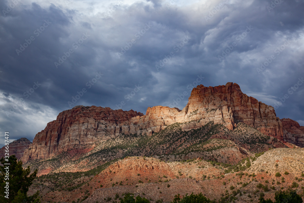Fototapeta premium Sunlight through the storm clouds on sandstone mountains in Zion National Park