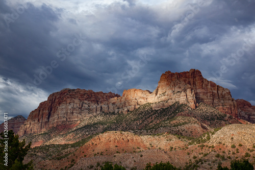 Sunlight through the storm clouds on sandstone mountains in Zion National Park © Krista.KW.Photo