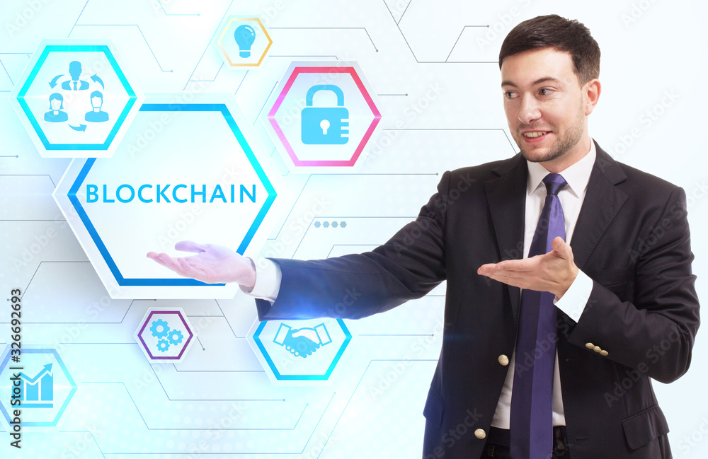 Business, Technology, Internet and network concept. Young businessman working on a virtual screen of the future and sees the inscription: Blockchain Business, Technology, Internet and network concept. Young businessman working on a virtual screen of the future and sees the inscription: Blockchain