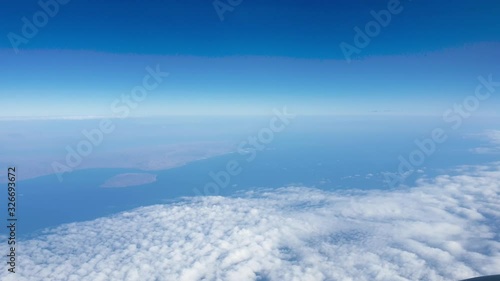 Wallpaper Mural 4k video of airplane flying above the ocean and land covered with clouds Torontodigital.ca