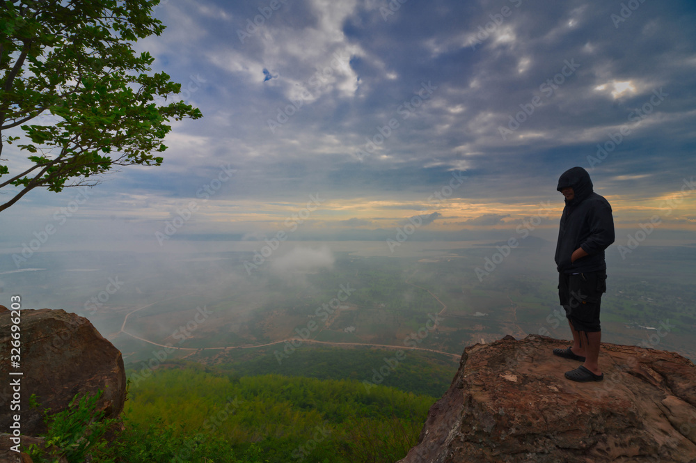 Man is standing and watching Beautiful Landscape of mountain and mist at morning sunrise of Khao Phraya Doenthong viewpoint in Lopburi province, Thailand... Outdoor adventure.. Concept.