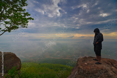 Man is standing and watching Beautiful Landscape of mountain and mist at morning sunrise of Khao Phraya Doenthong viewpoint in Lopburi province, Thailand... Outdoor adventure.. Concept.