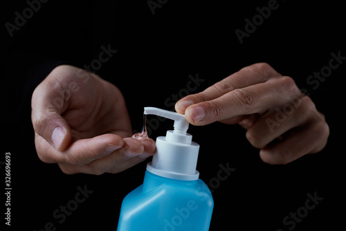 man disinfecting his hands with hand sanitizer