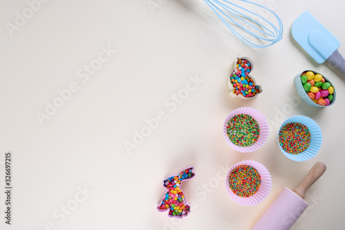 Preparation of gingerbread cookies. Easter cookies cutters, tools necessary to make gingerbread pastry, colored sprinkles. Easter concept.