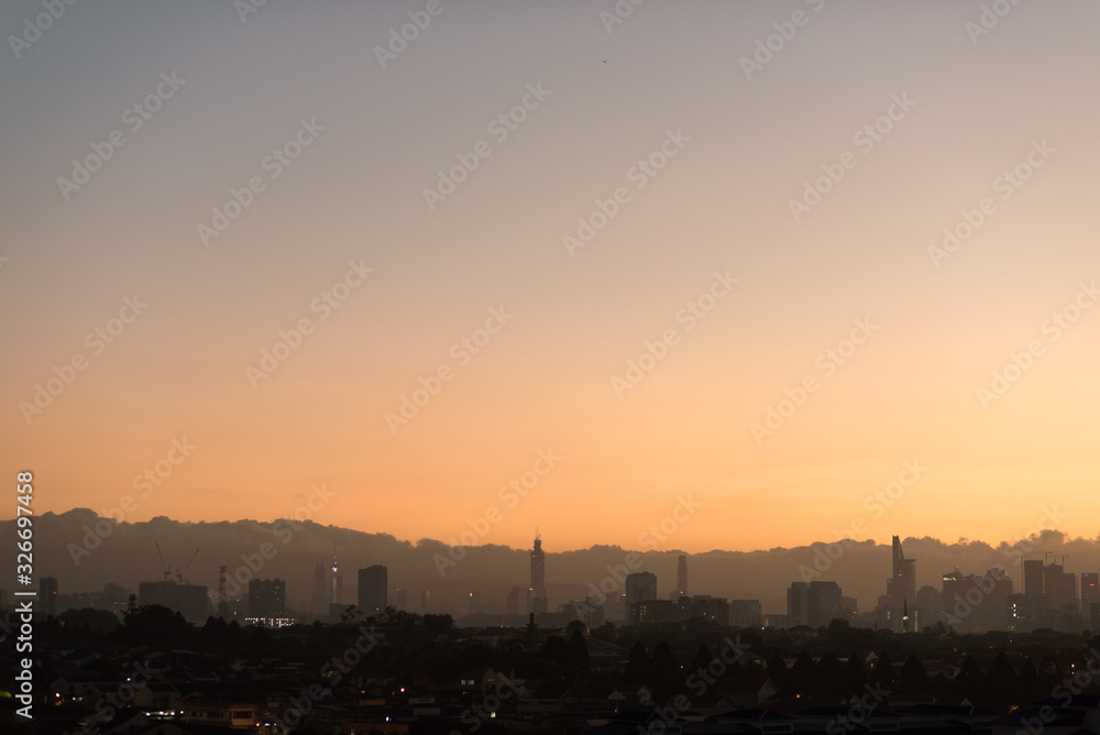 Scenic view of Kuala Lumpur city skyline against dawn sky with low clouds. Kuala Lumpur skyline view with copy space