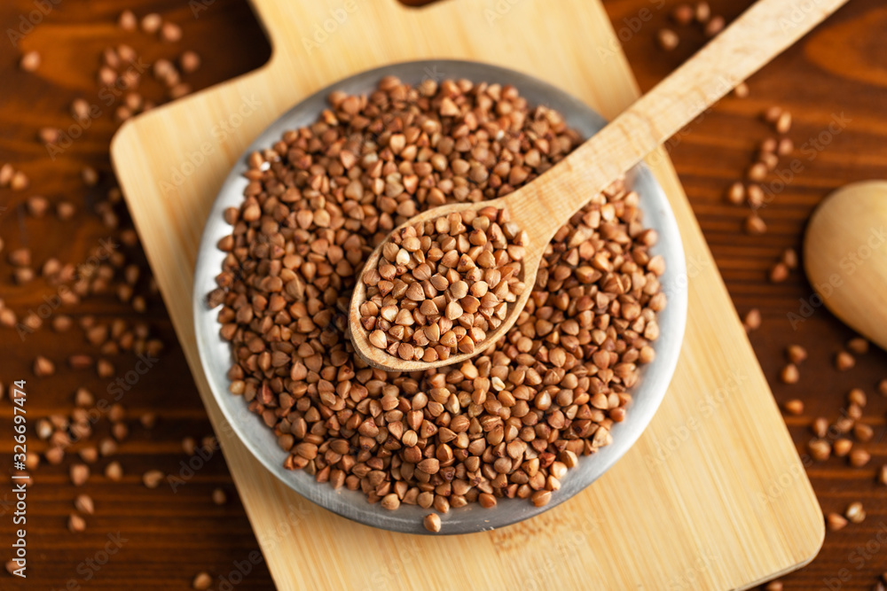 Buckwheat in bowl on table, spoons, top view Buckwheat in bowl on table, spoons, top view