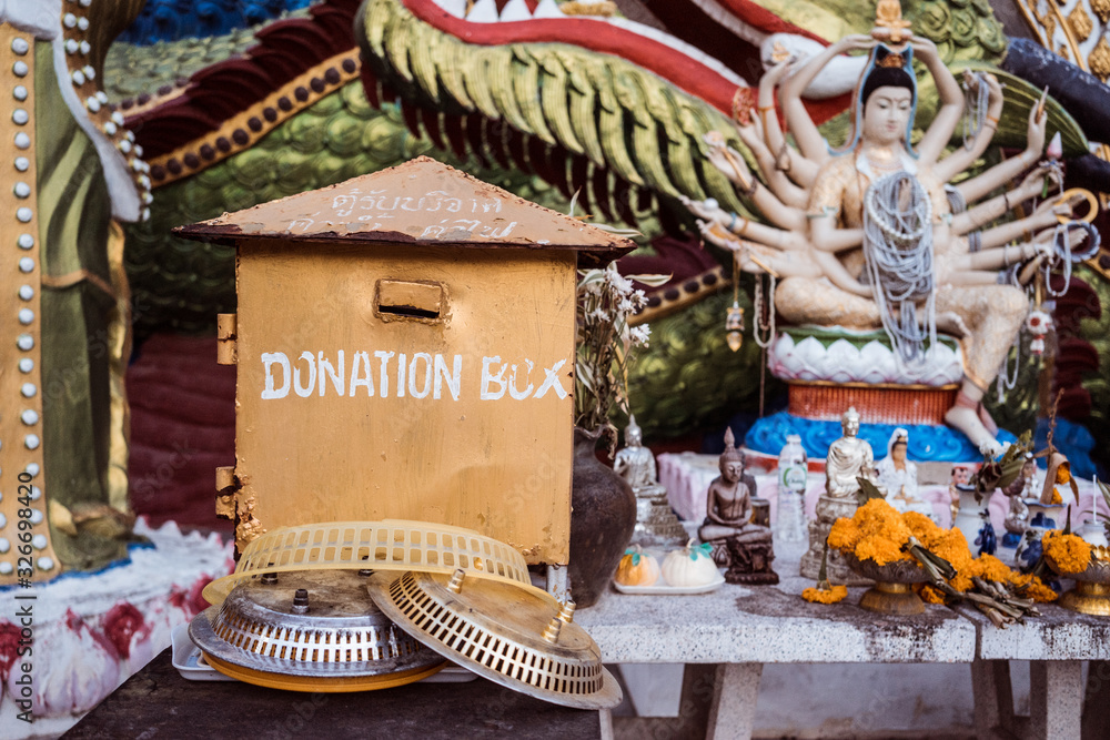 Box with donations in the temple of Thailand. Travel to Asia attractions.
