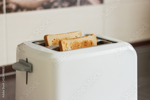 Slices of toasted bread in a white toaster.