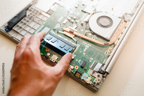Fotografia memory module ddr4 ram installation in laptop by hand