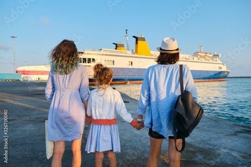 Photographie Sea family vacation, mother and daughters in the seaport looking at the ferry