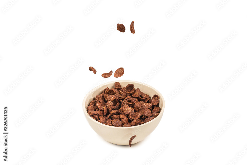 Chocolate corn flakes falling to the white bowl isolated on white. Motion. Chocolate corn flakes falling to the white bowl isolated on white. Motion.