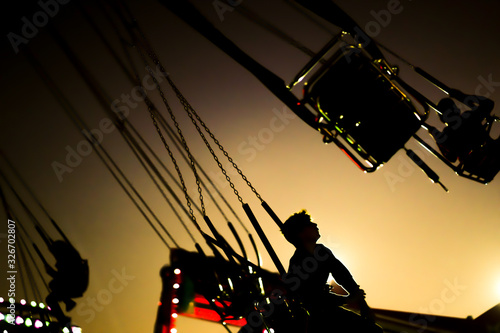 silhouette ofa young boy riding on a merry-go-round swing
