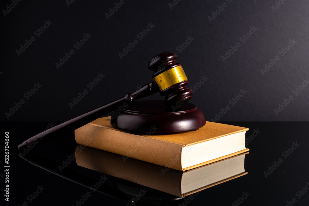 Gavel hammer and book with low light view. Educational concept.